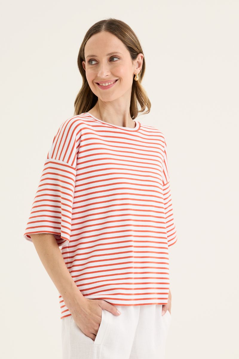 Woman wearing a red and white striped shirt against a plain background