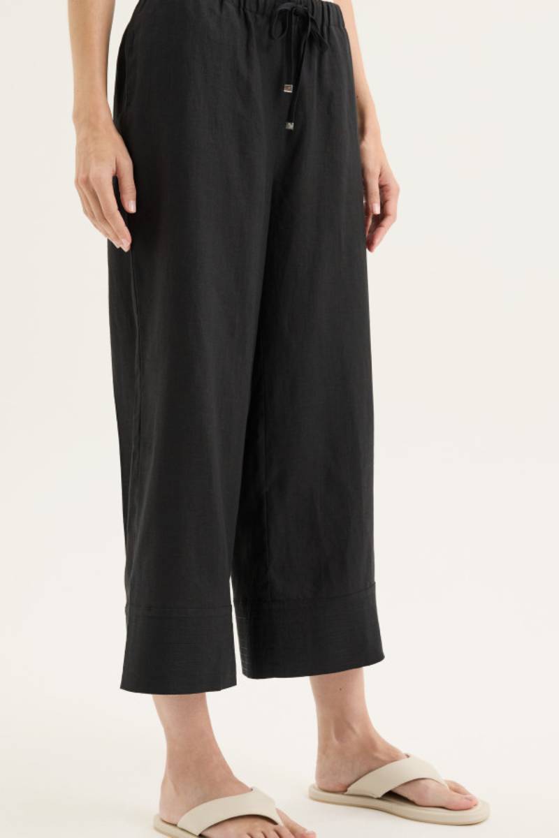 Side view of model wearing Yarra Trail Tirari Palazzo Pant in 100% linen — wide-leg 7/8 length style with elastic waistband and herringbone tie.