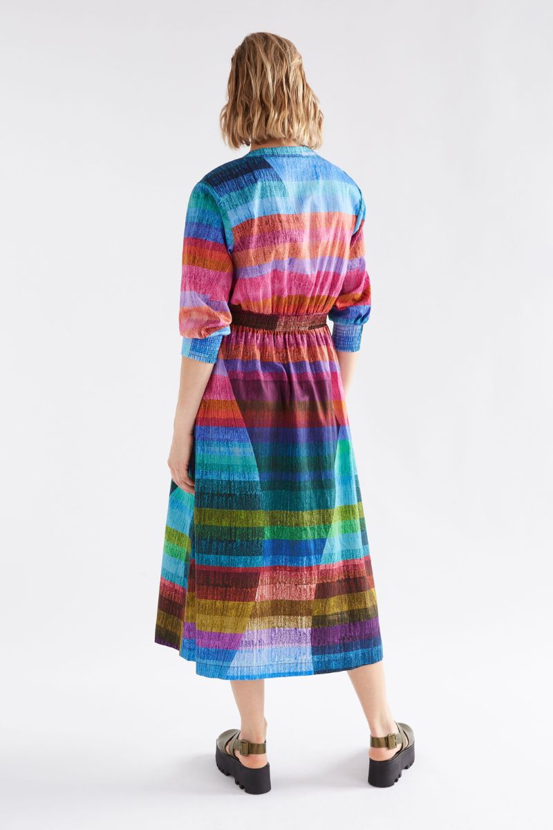 Back view  wearing a colorful striped dress on a white background
