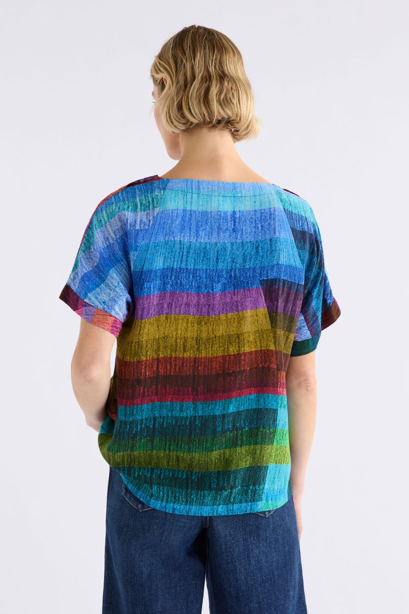 Person wearing a colorful sono top back view with a plain background