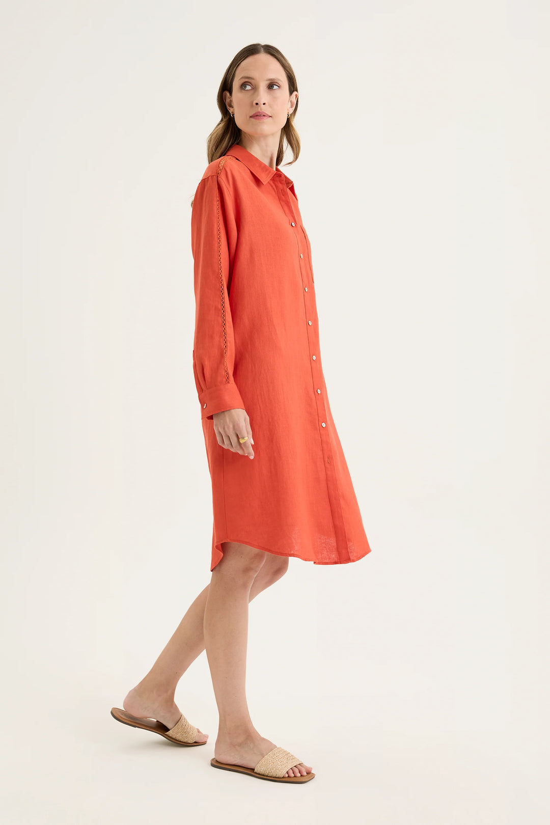 Side view of woman wearing Yarra Trail Tirari Shirtmaker Dress in Volcanic red YTWN9639 against white background