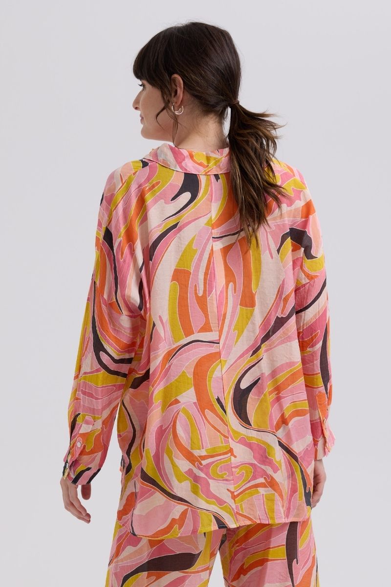 Woman wearing a colorful patterned outfit on a white background