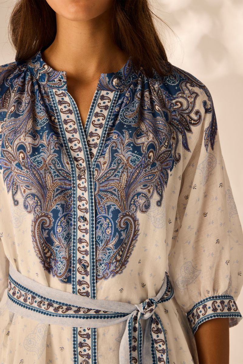 Woman wearing a blue and white patterned dress with a blurred background