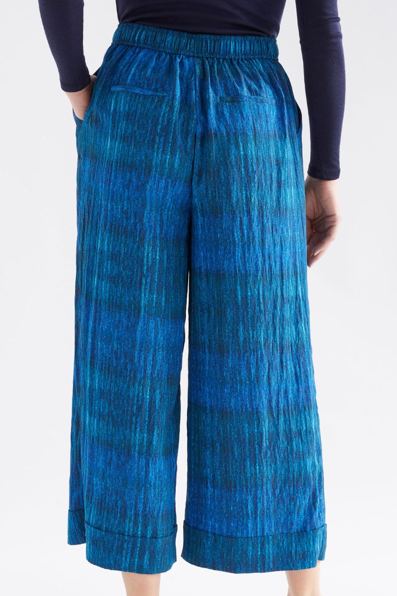 Blue patterned pants worn by a person on a white background