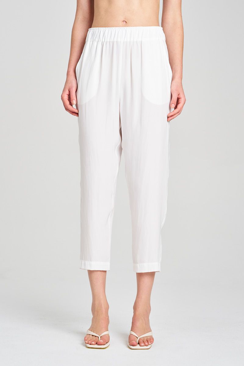 White pants worn by a person on a plain background