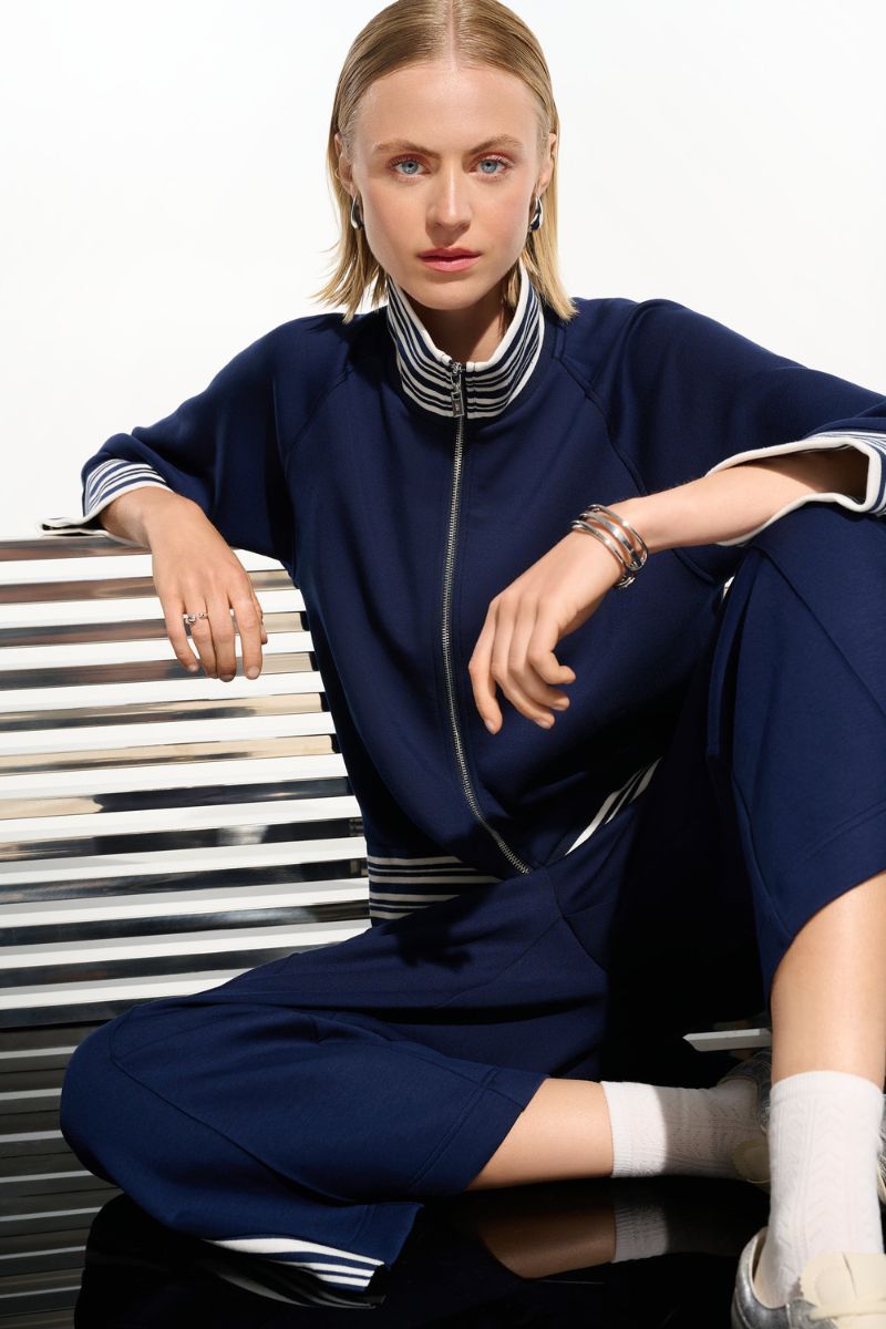 Woman wearing Joseph Ribkoff 261617 Scuba Jersey Jacket with Funnel Collar in Indigo Vanilla front view