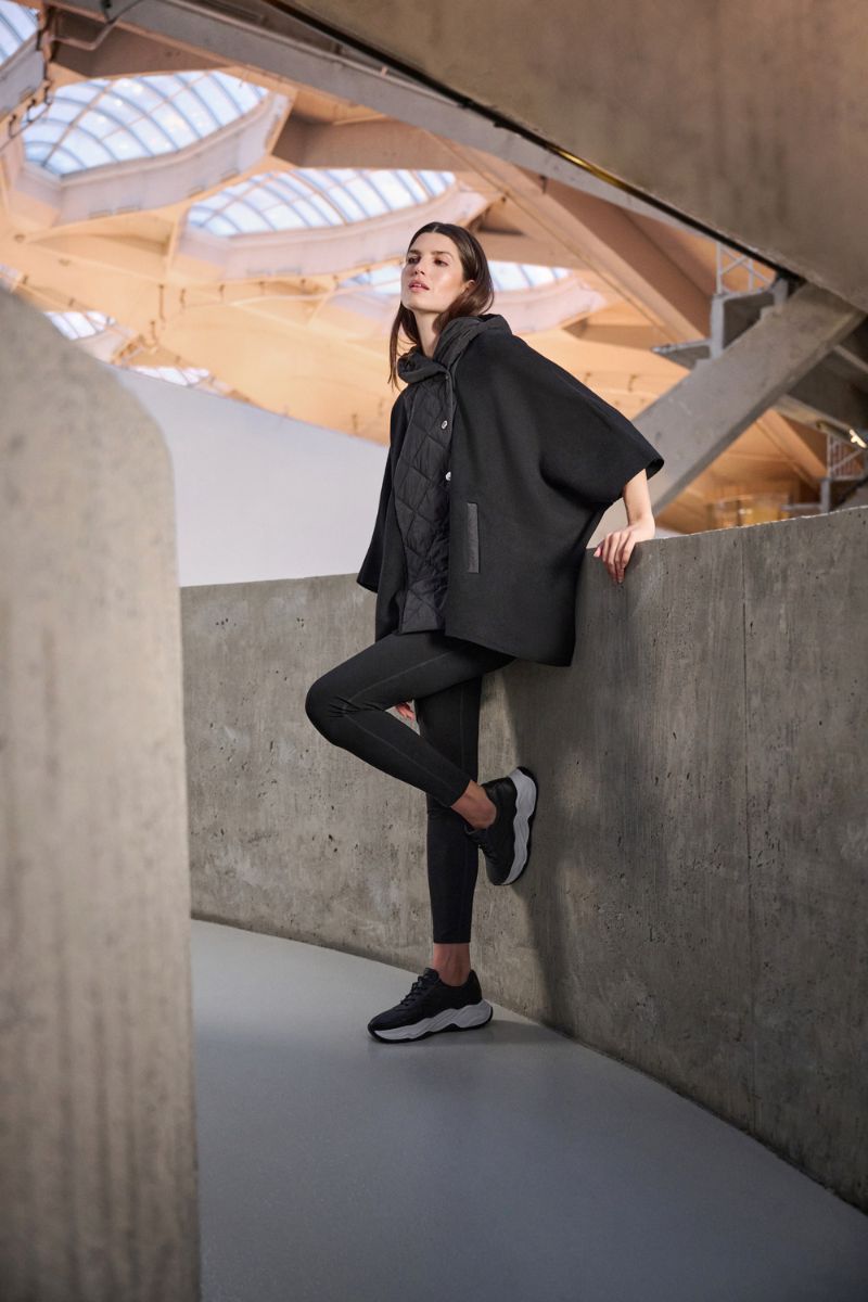 Woman wearing Joseph Ribkoff black compression leggings and Black Cape