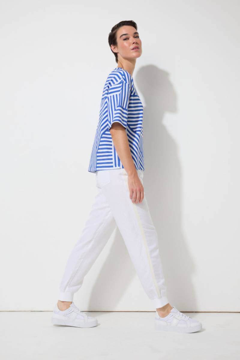 Side view of a model wearing the Marco Polo Spliced Stripe Tee — a soft cotton-elastane top with a contrasting spliced-stripe print, crew neckline, and elbow-length sleeves.