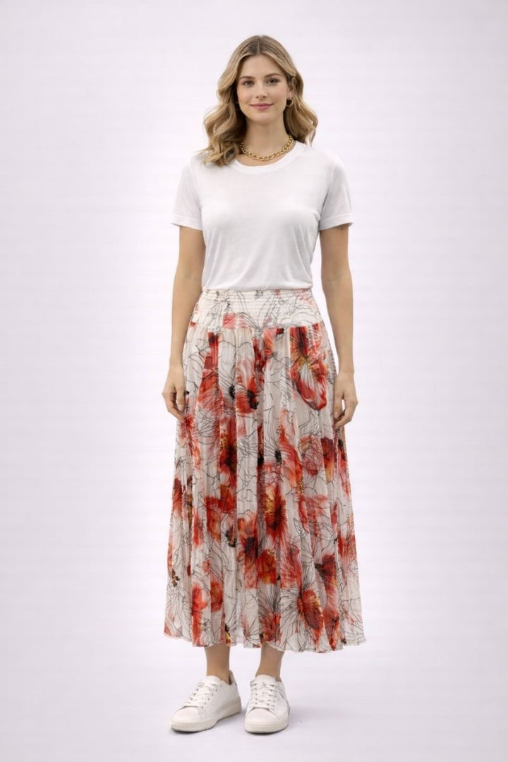 Woman wearing a white t-shirt and a patterned skirt on a white background