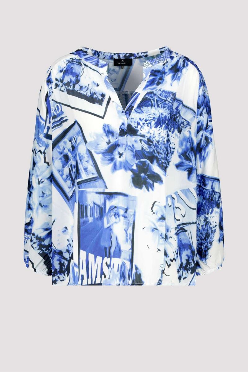 Blue and white floral and abstract patterned blouse on a light gray background