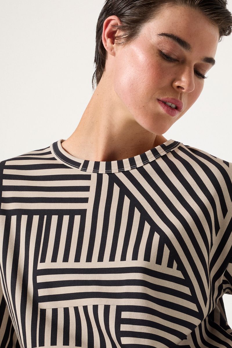 Person wearing a black and white striped shirt against a plain background