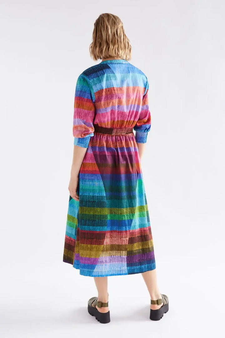 Back view  wearing a colorful striped dress on a white background