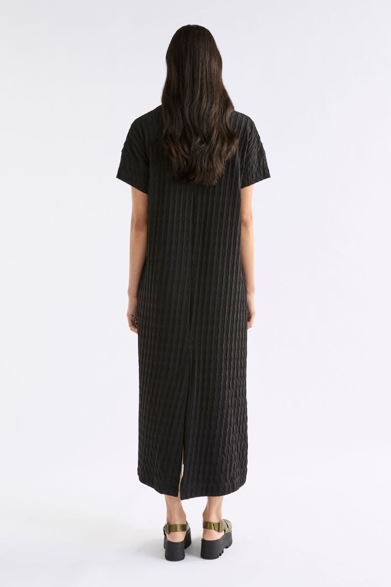 Back view of person wearing a black dress with a white background