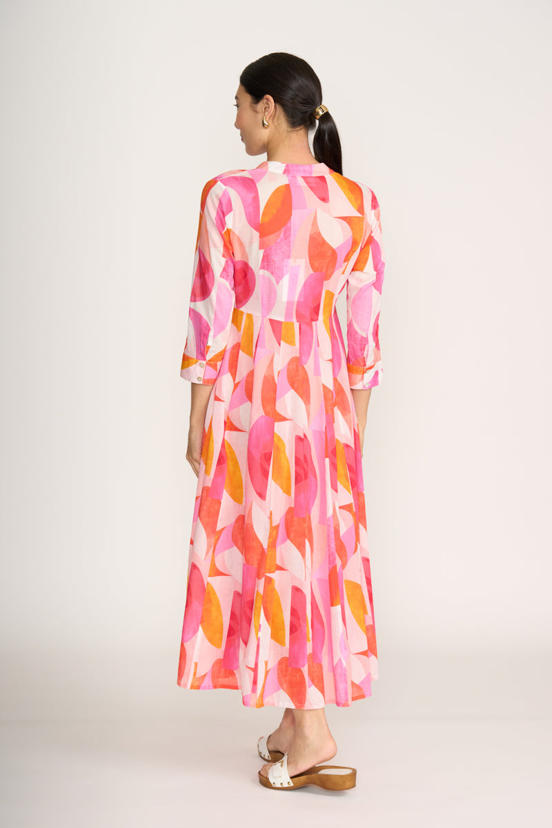 Woman wearing a colorful dress with abstract pattern on a white background