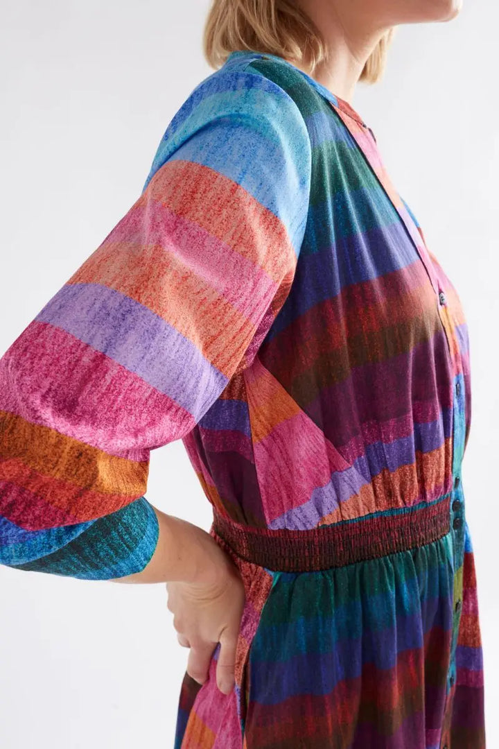 Person wearing a colorful striped dress with a white background