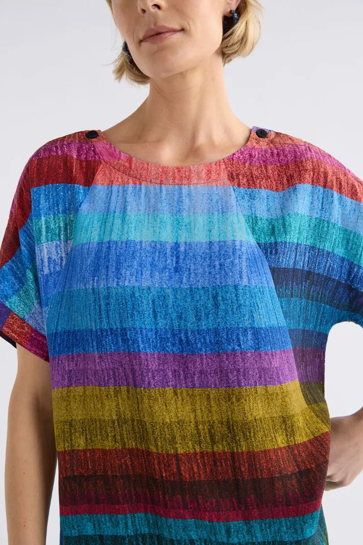 Woman wearing a colorful striped shirt with a white background