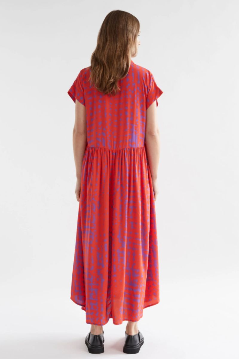 Back view of Woman wearing a red dress with blue patterns on a white background