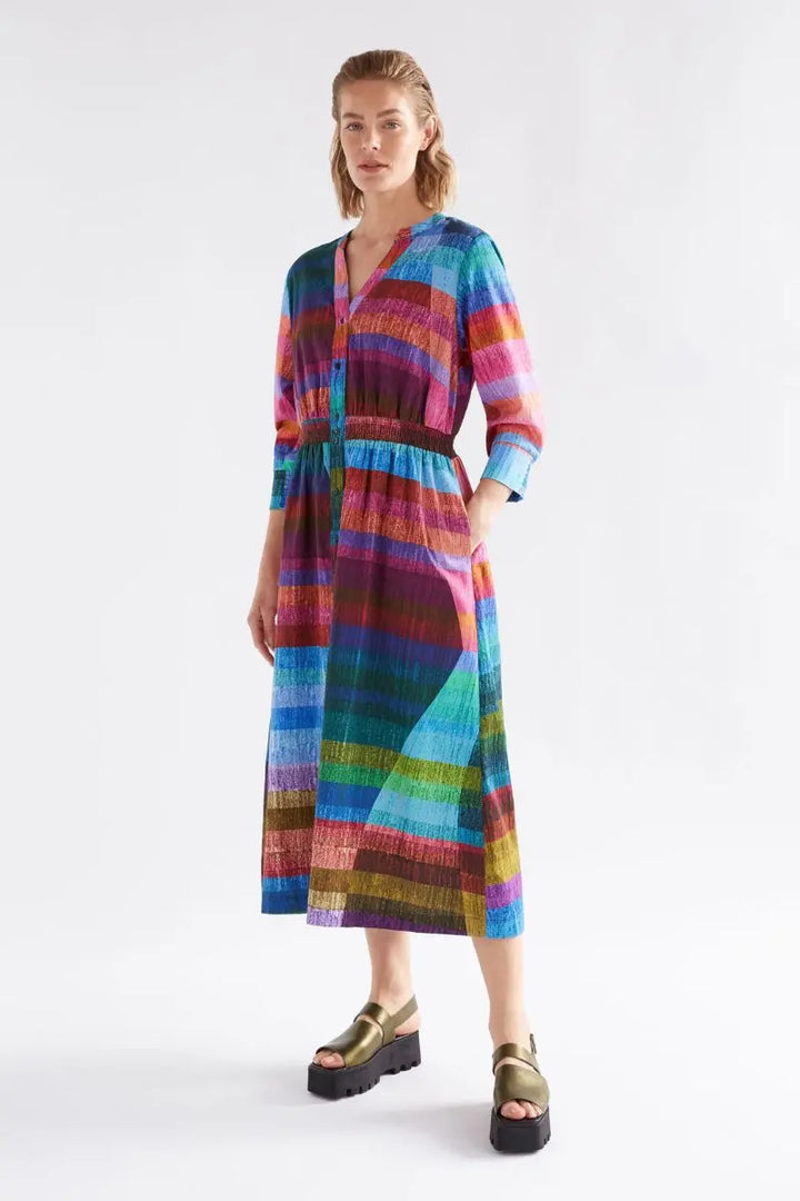 Woman wearing a colorful striped dress on a white background