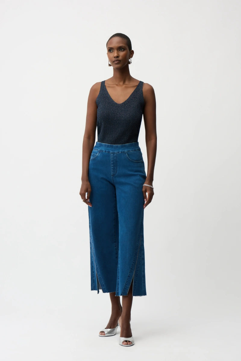 Woman wearing Joseph Ribkoff 252915S26 Metallic Knitted Camisole with Rhinestones in Midnight Blue with blue denim jeans  front view