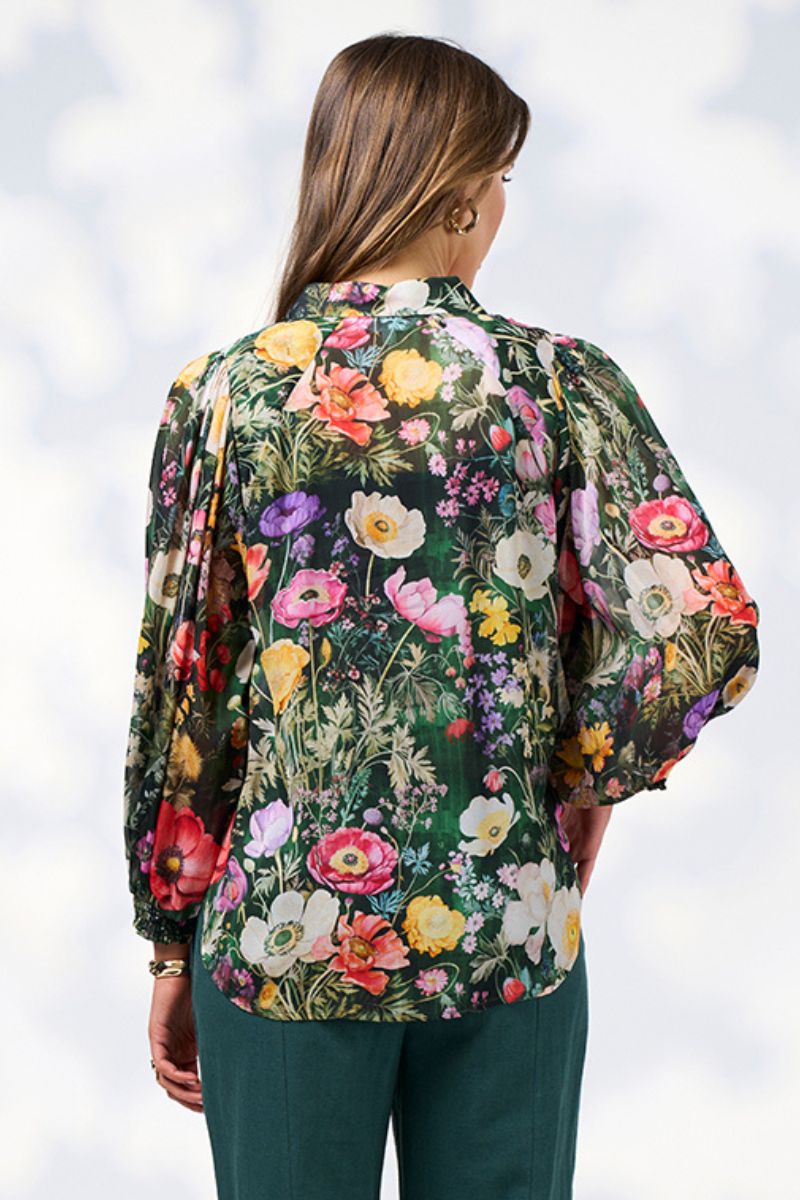 Back view of a Woman wearing a floral blouse with a blurred background