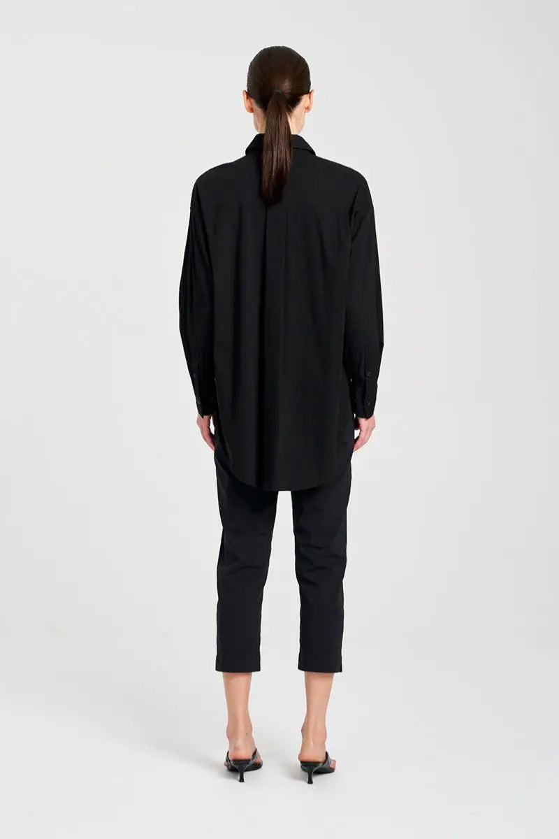 Back view of Person wearing a black coat and pants on a white background