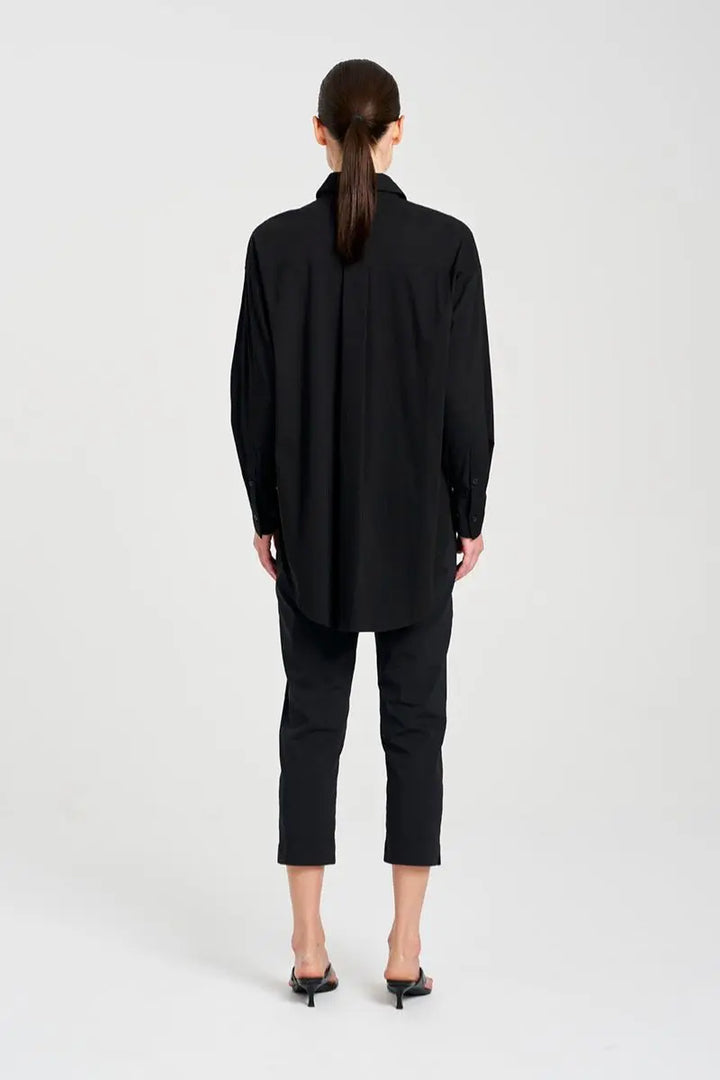 Back view of Person wearing a black coat and pants on a white background