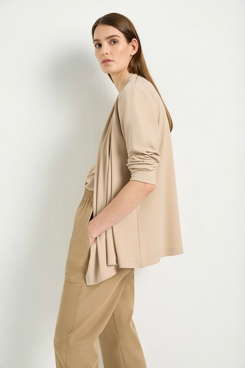 Woman wearing Mela Purdie Peak Jacket F007 4147 with tan pants against white background