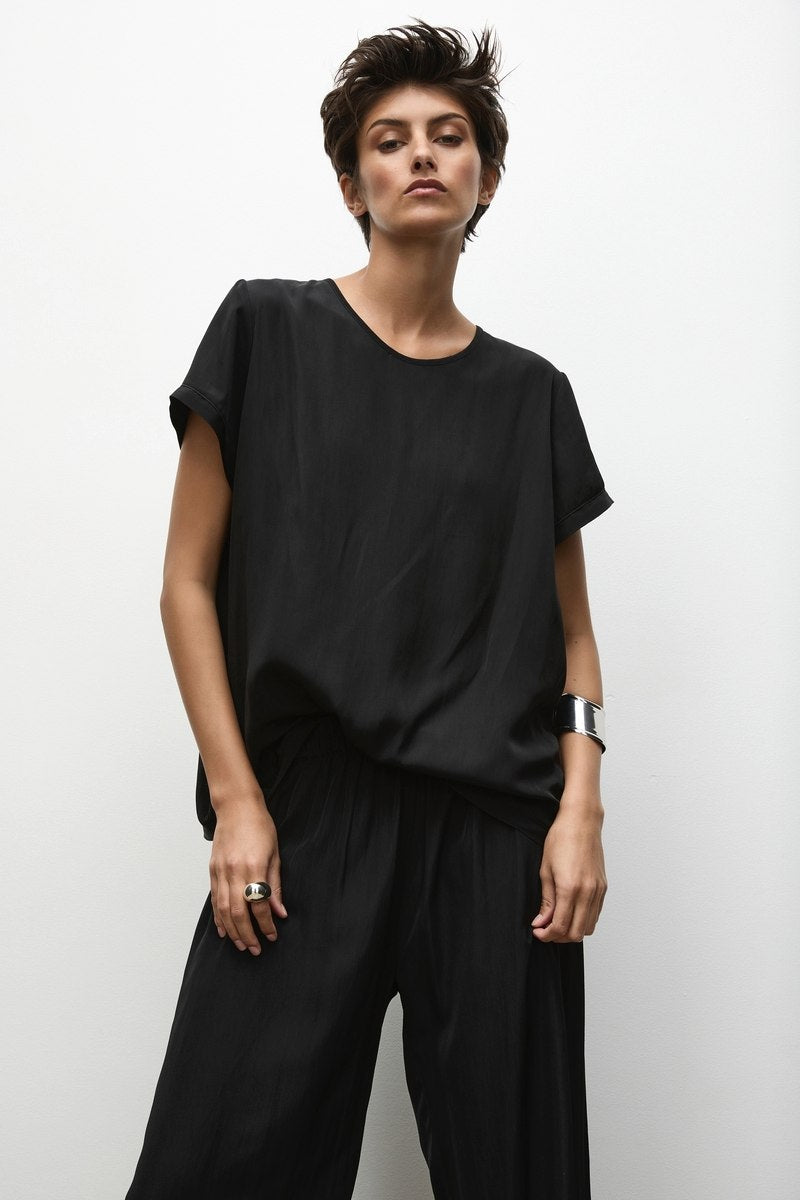 Woman wearing Mela Purdie Transit T in Black F67 2203 and Pace Pant F67 1740 in black against white background