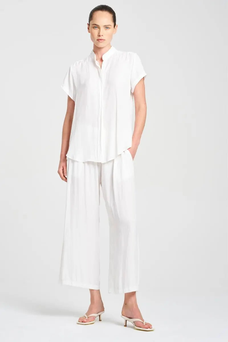Woman wearing a white outfit on a plain background