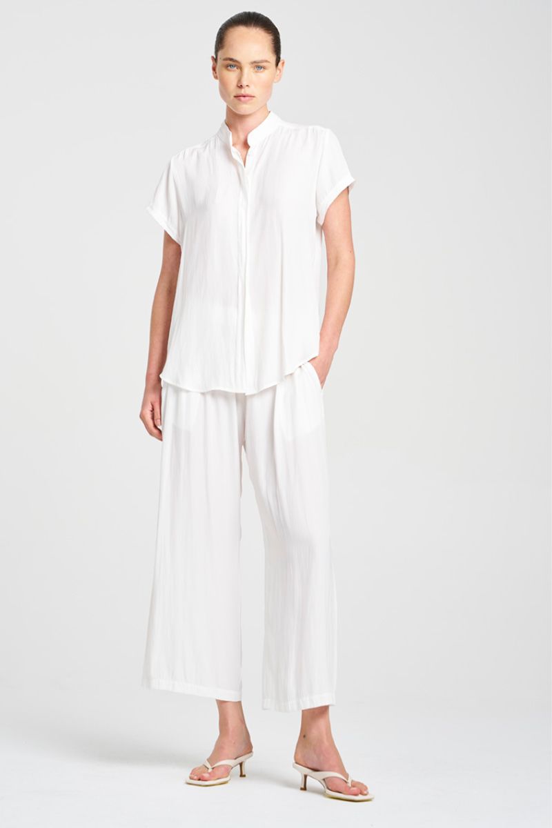 Woman wearing a white outfit on a plain background