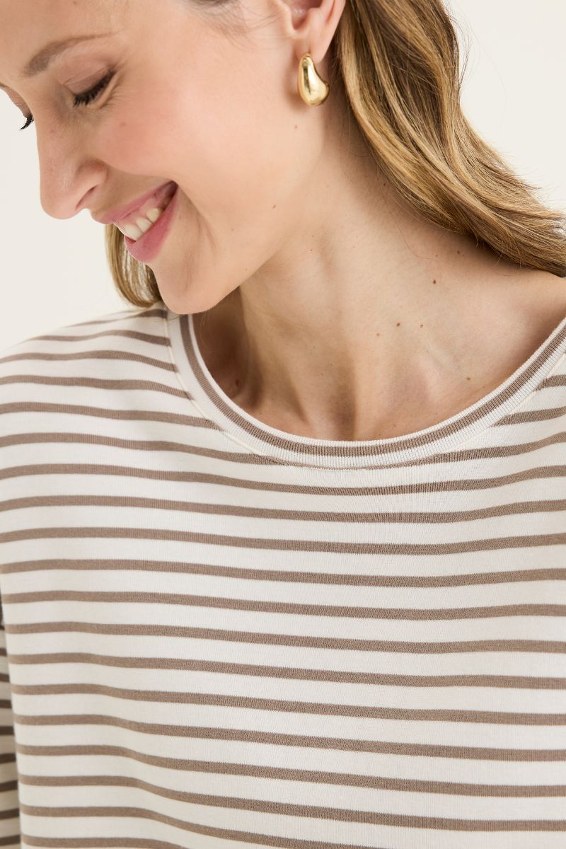 Woman wearing a striped shirt with a close-up of her face and earring.