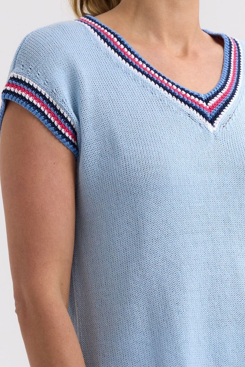 Light blue knit top with colorful trim on a plain background