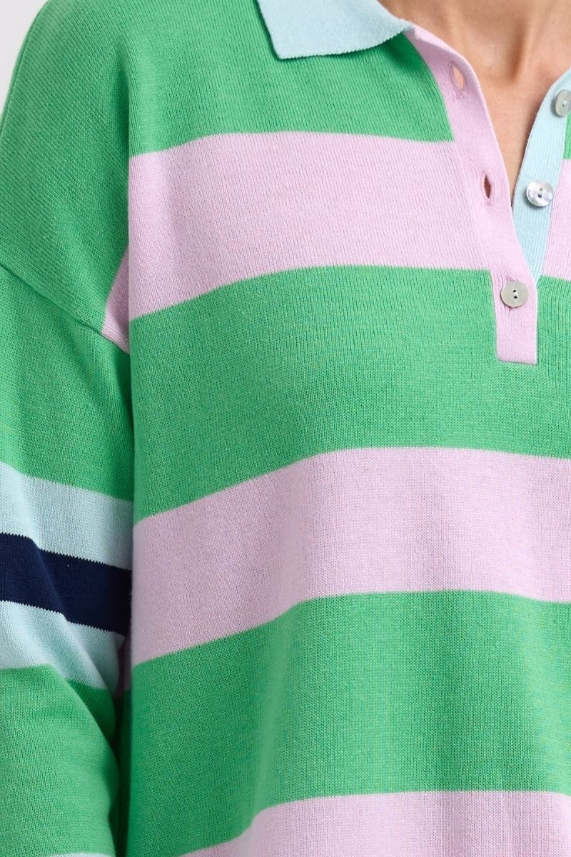 Close-up of a person wearing a green and pink striped polo shirt.