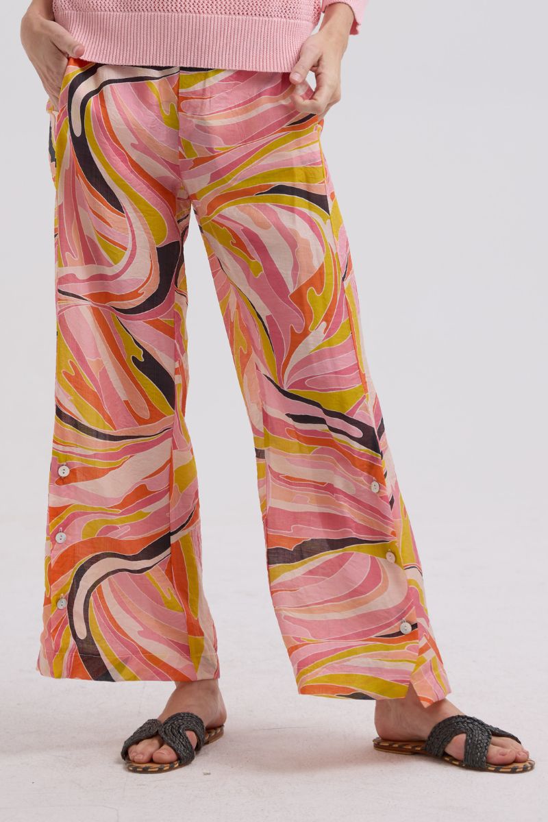 Person wearing colorful patterned pants on a plain background