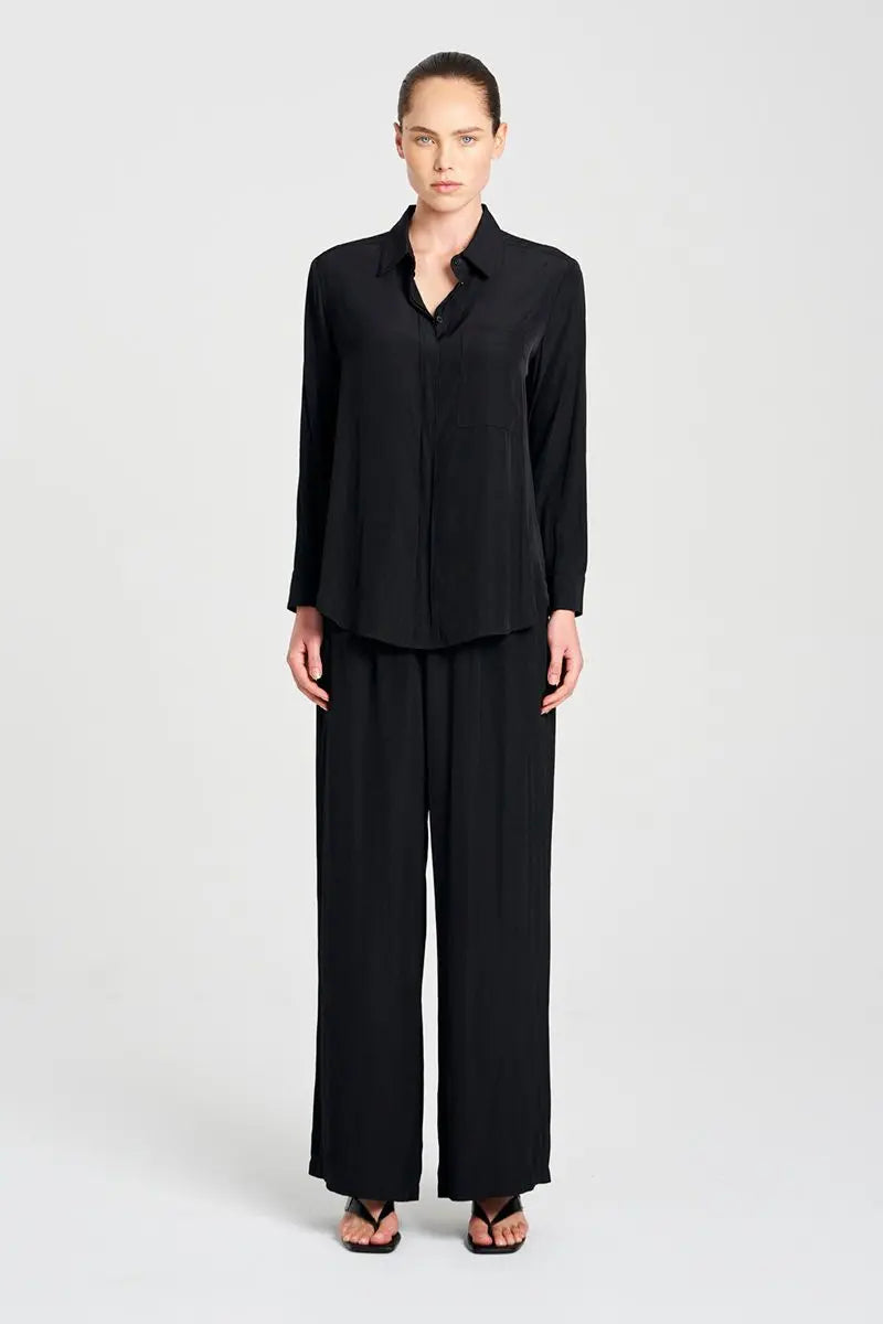 Person wearing a black outfit on a white background