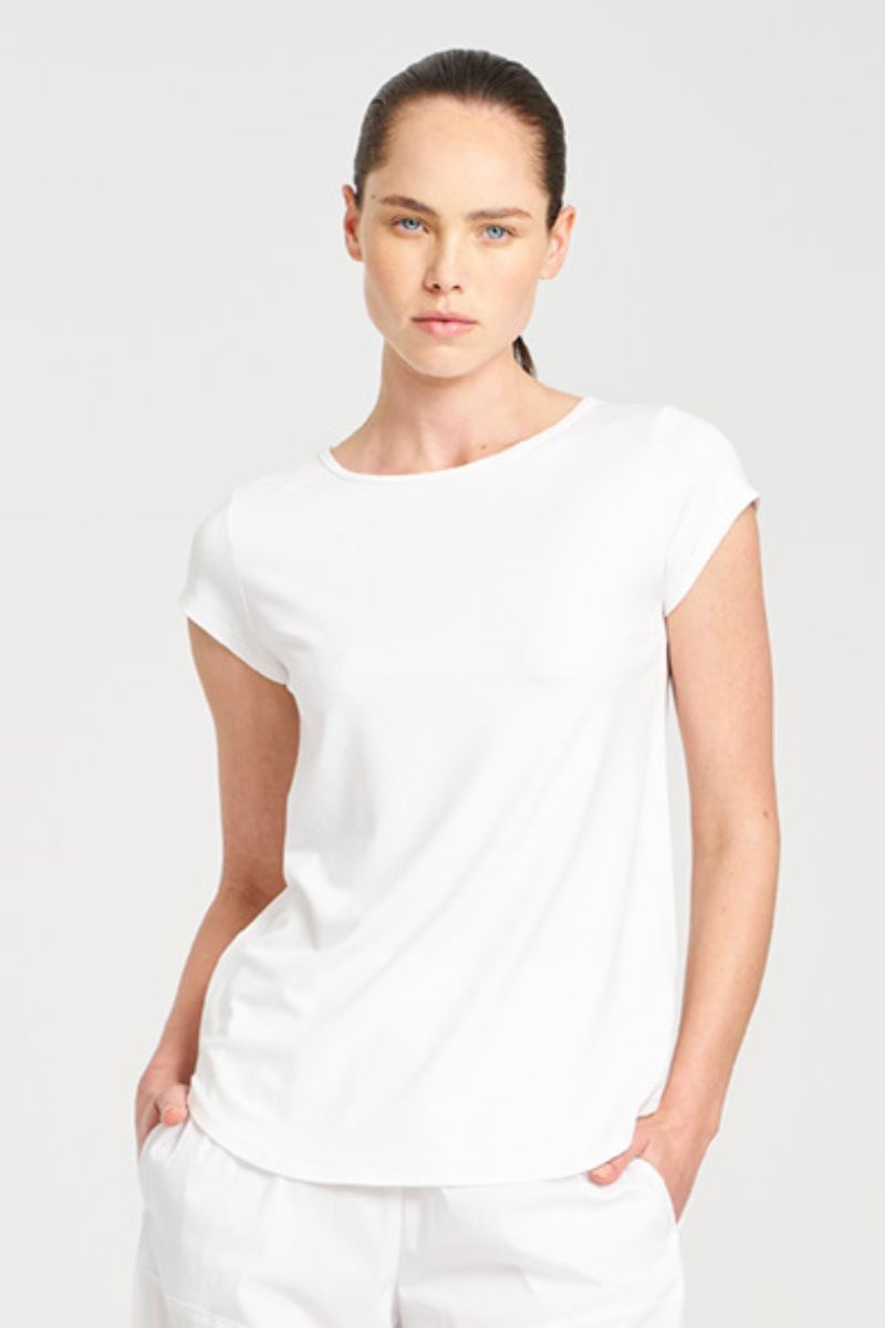 Woman wearing a white t-shirt and pants on a plain background