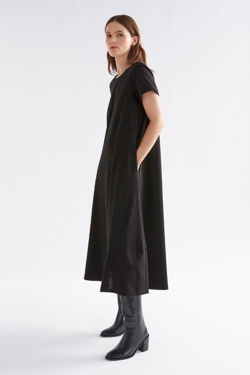 Woman wearing a black dress with short sleeves and a white background