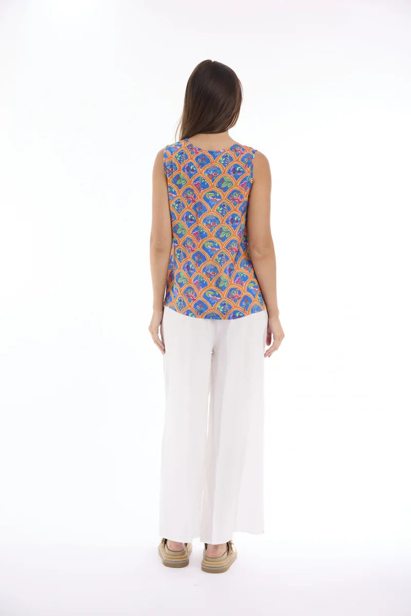 Woman wearing Escape by Orientique Aurora Cami 12297 in Print, back view with white trousers