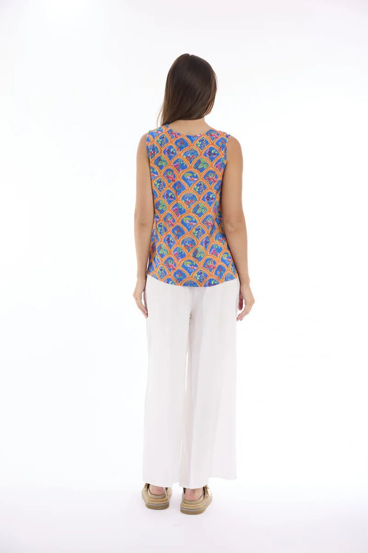 Woman wearing Escape by Orientique Aurora Cami 12297 in Print, back view with white trousers