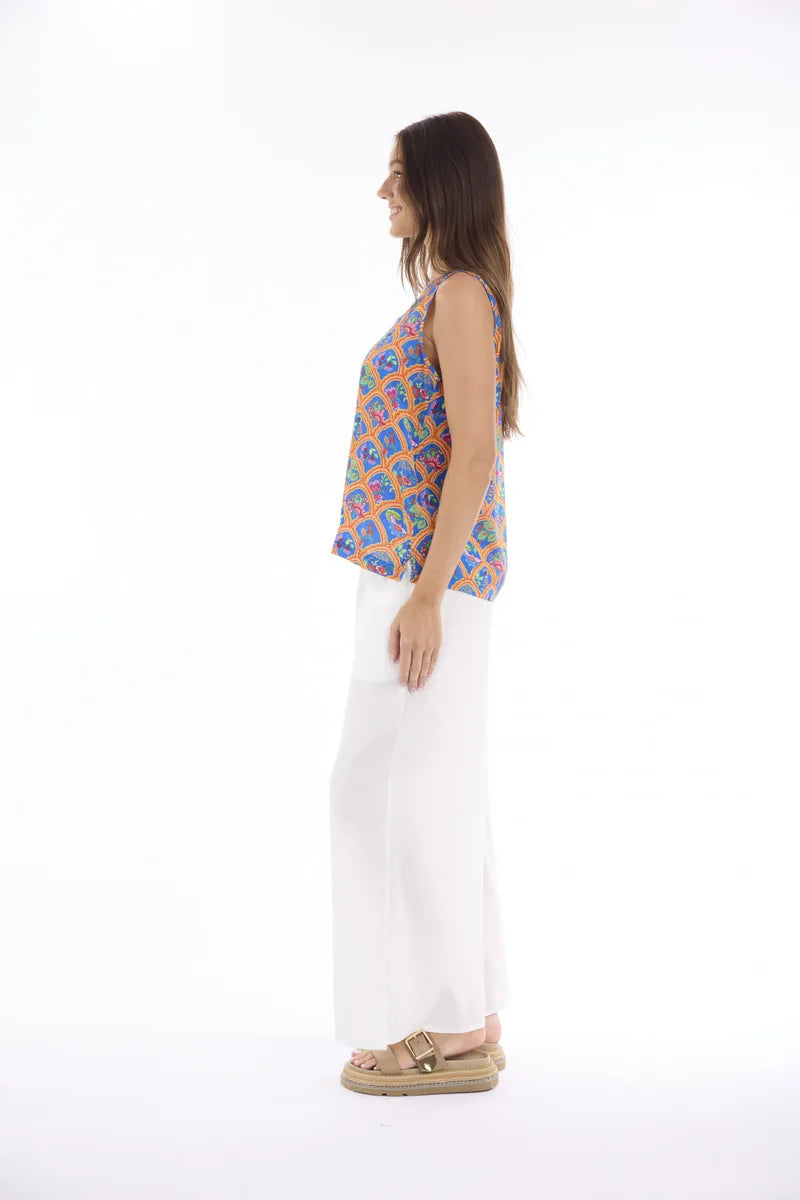 Woman wearing Escape by Orientique Aurora Cami 12297 in Print, side view with white trousers