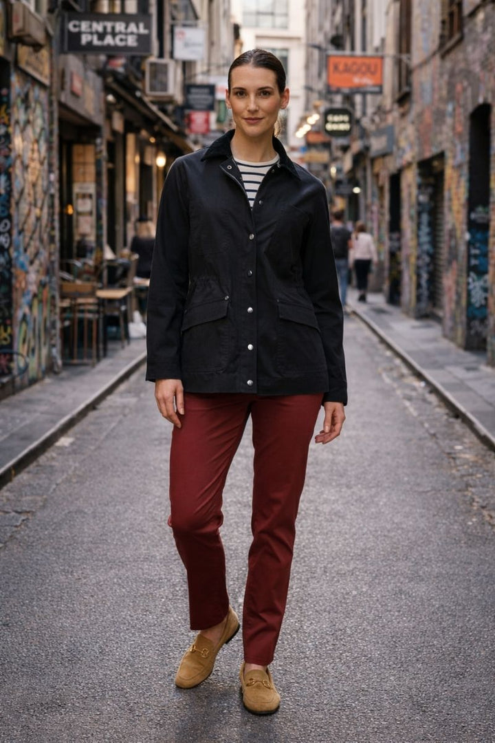 Women Wearing Foil clothing wine red trousers, stripes top and the hidden treasures jacket in Dark Navy blue indigo with silver buttons and two angled pockets walking in a street