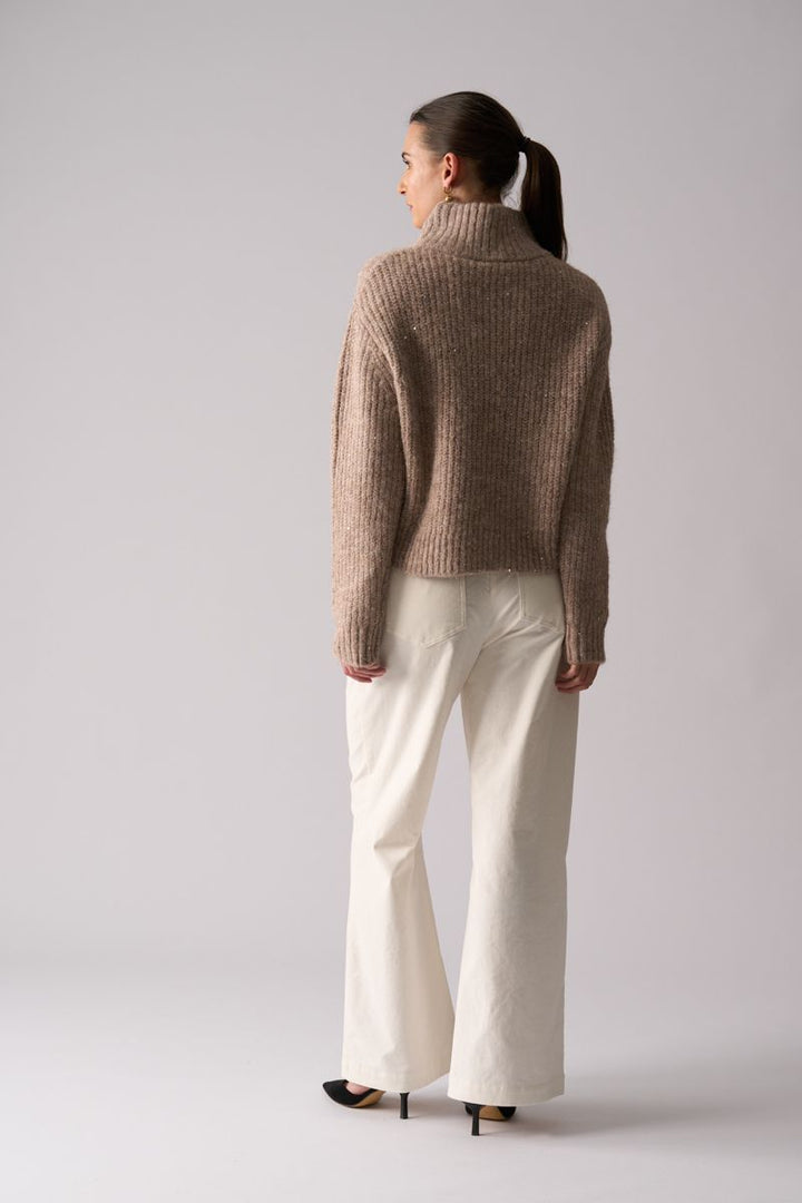 Woman wearing Glow Getter Sweater in Oat by Foil back