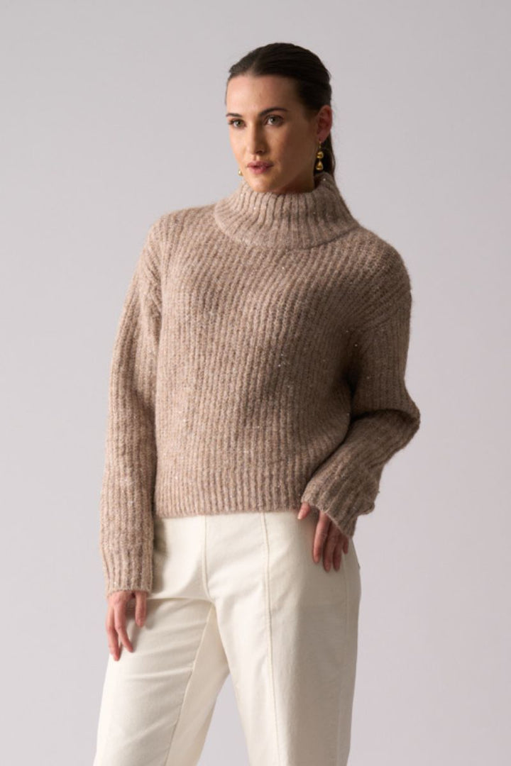 Woman wearing Glow Getter Sweater in Oat by Foil front