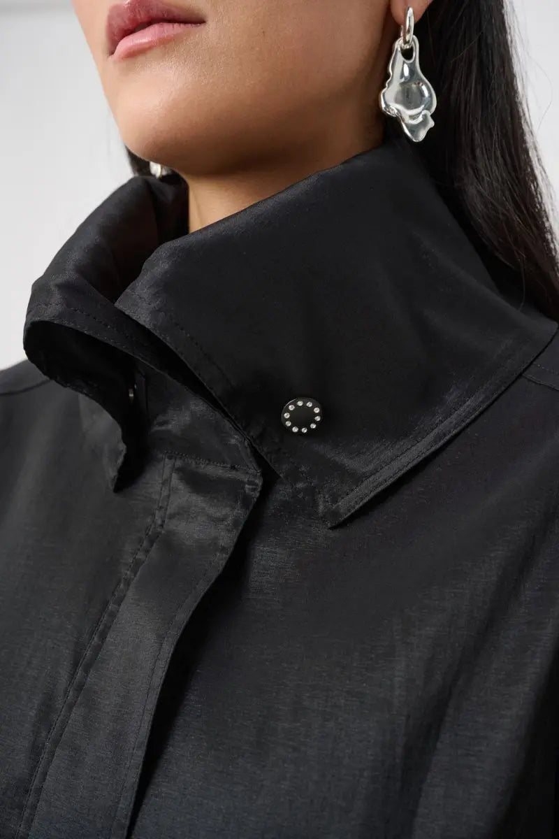 Woman wearing Joseph Ribkoff black stretch taffeta coat snap collar detail