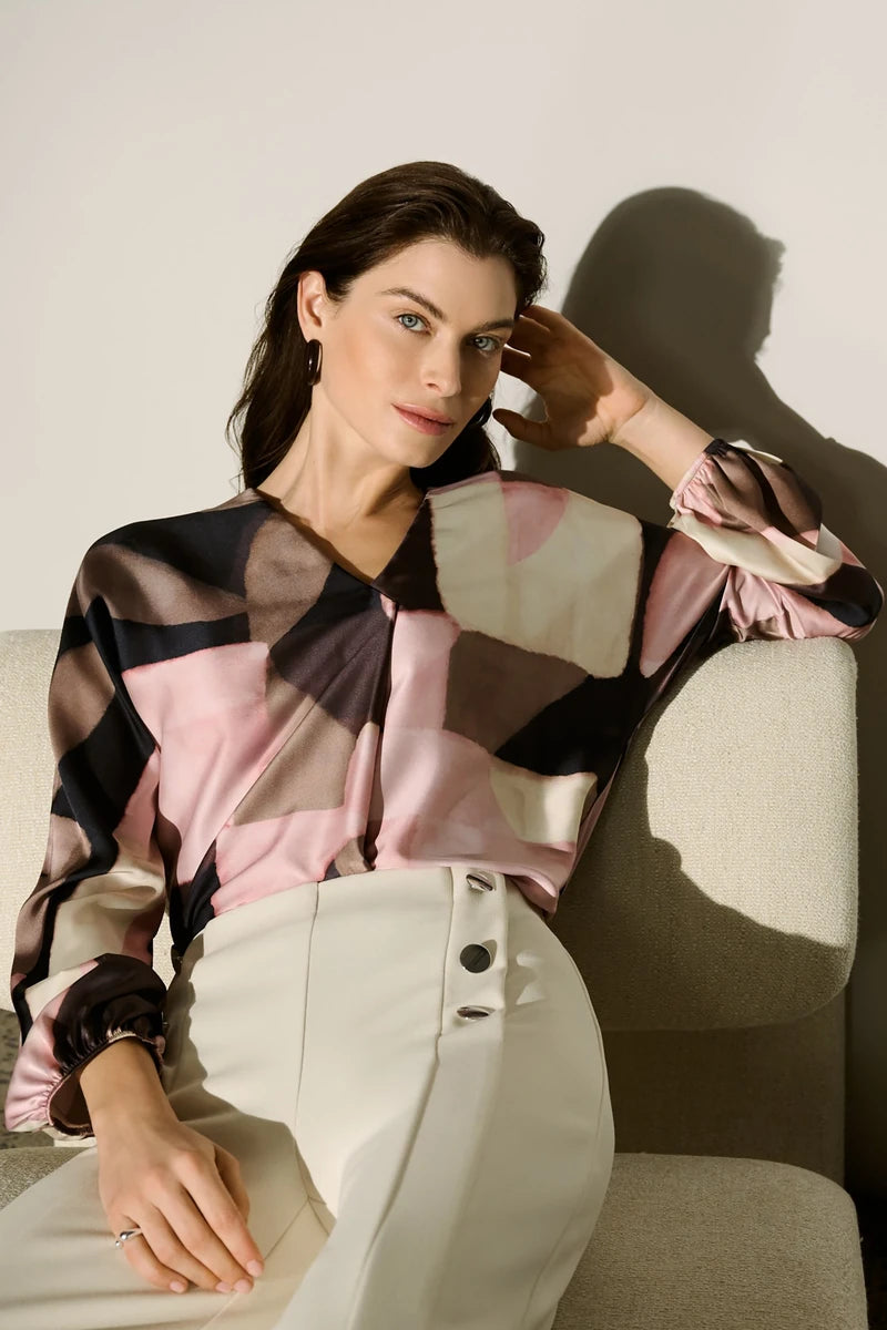 Joseph Ribkoff 264197 geometric print recycled satin top styled with cream trousers, showing the relaxed sleeve and satin drape.