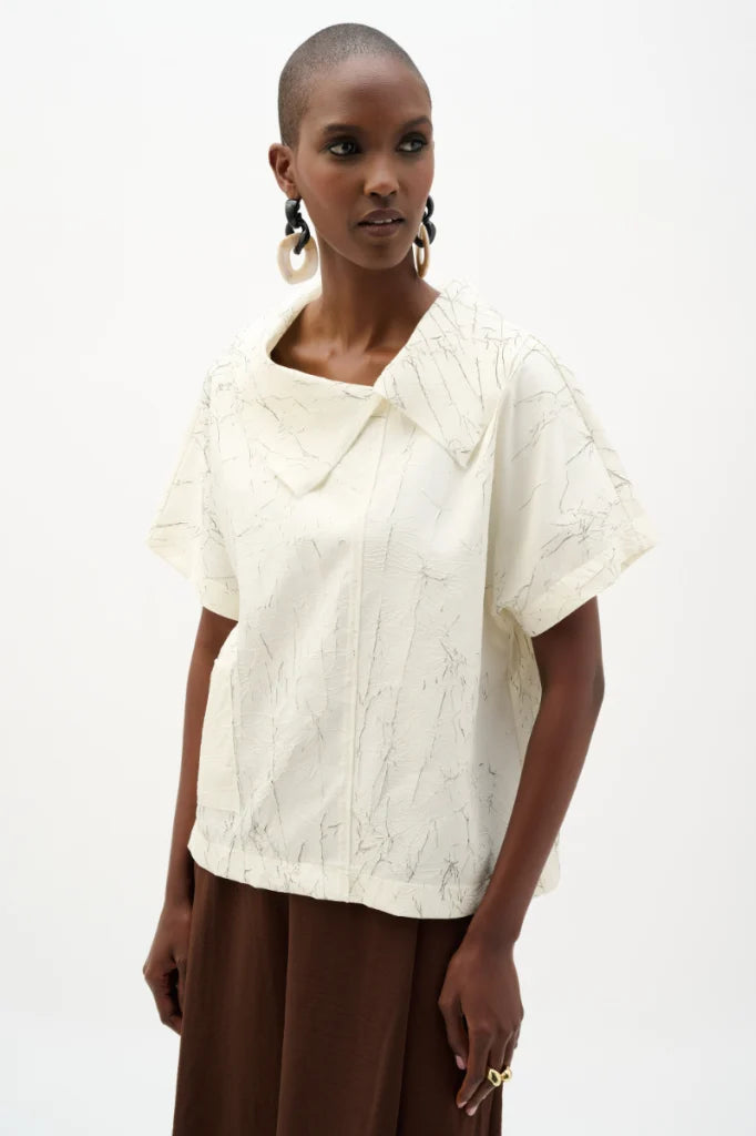 Woman wearing joseph ribkoff 262088 novelty abstract print boxy top with cowl collar cream front