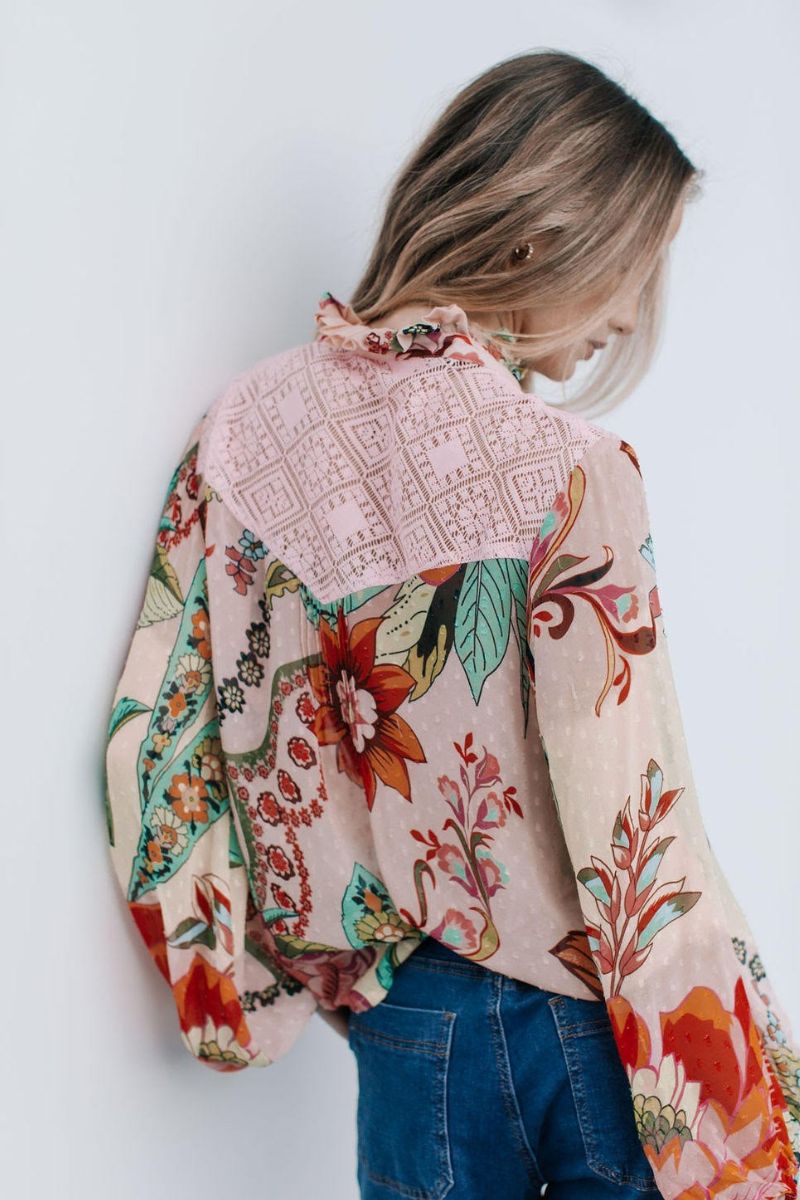Back view of Person wearing a colorful floral-patterned jacket against a white background