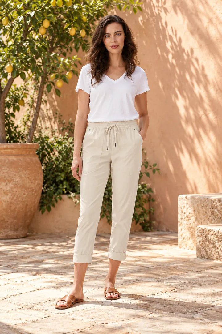 Lania Port 7/8 pants in almond, styled with a plain white V-neck tee in a citrus courtyard.