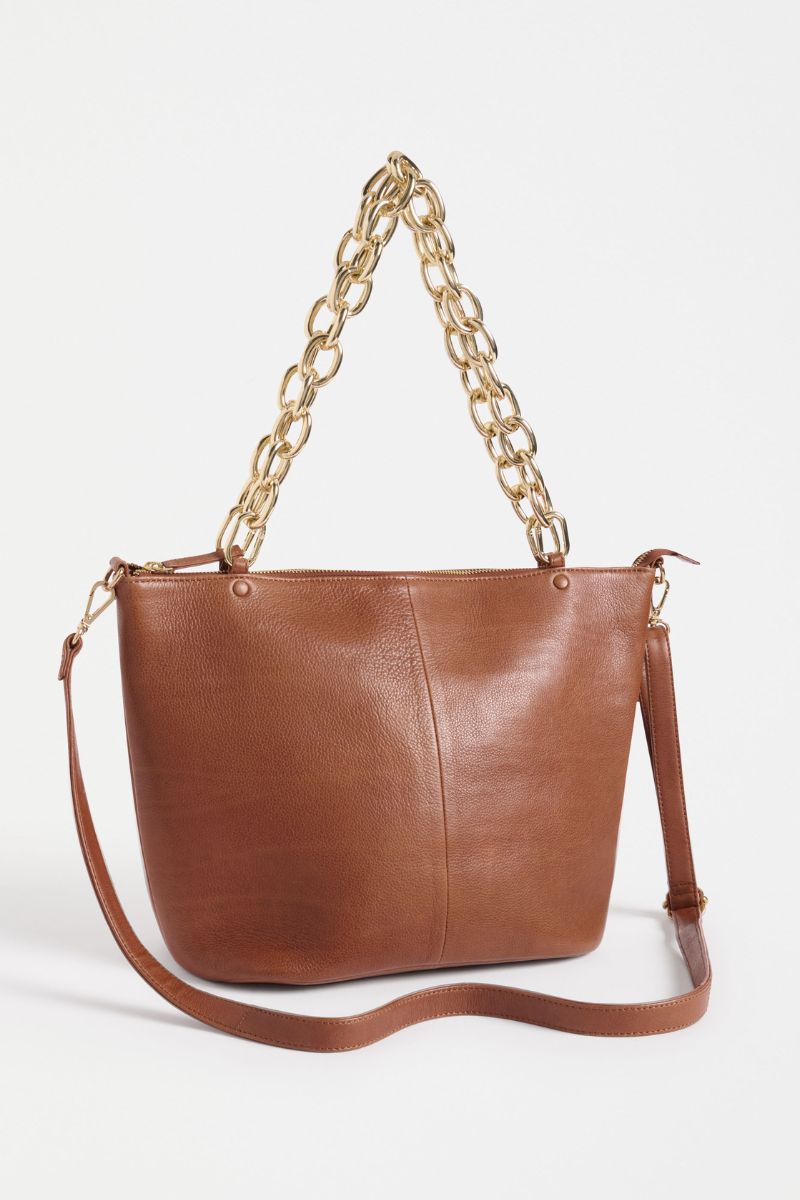 Brown leather handbag with gold chain handle on a white background