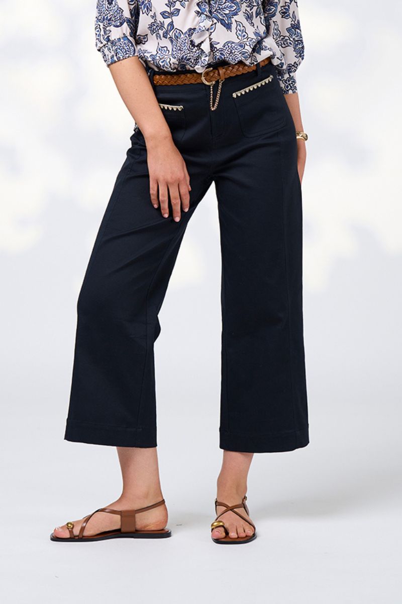 Person wearing navy wide-leg pants with a white background